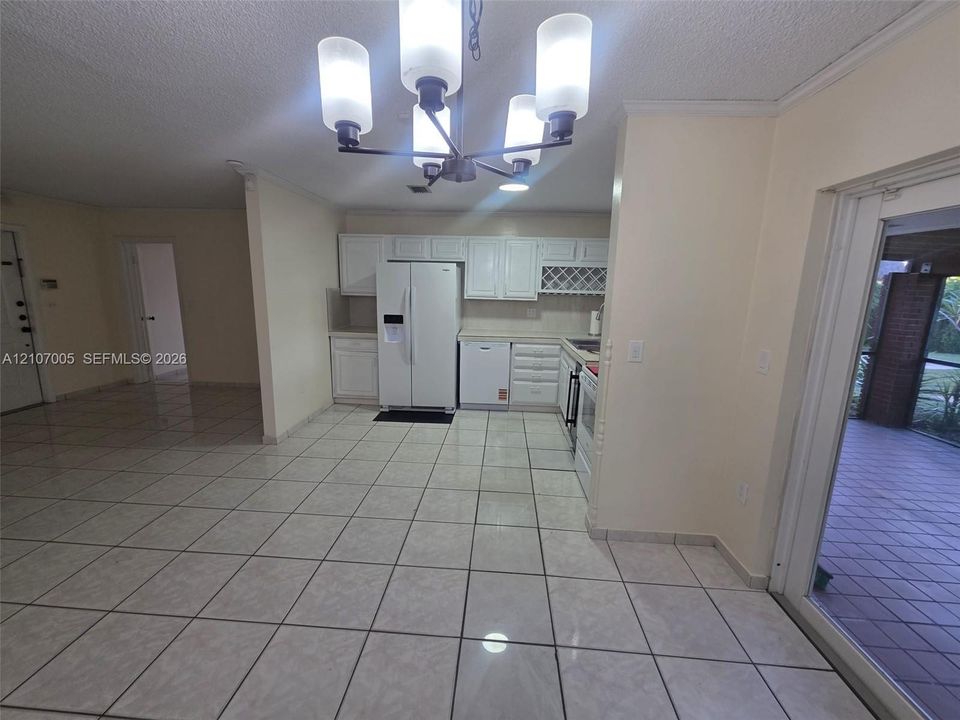 Kitchen featuring white cabinetry, built-in wine rack, tile flooring, and multi-light chandelier
