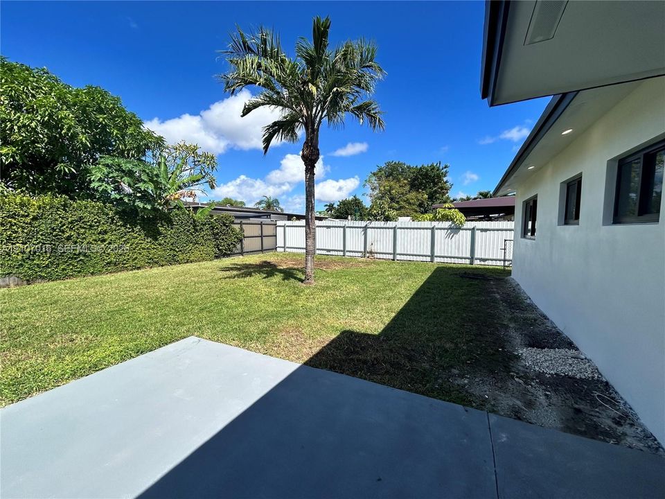 Expansive backyard, perimeter fencing, and concrete patio