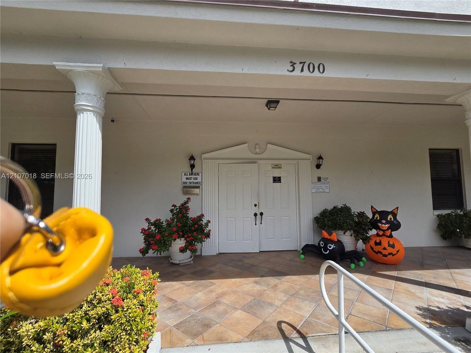 Covered entryway featuring decorative fluted columns, a tiled porch, and double-door entry with architectural molding