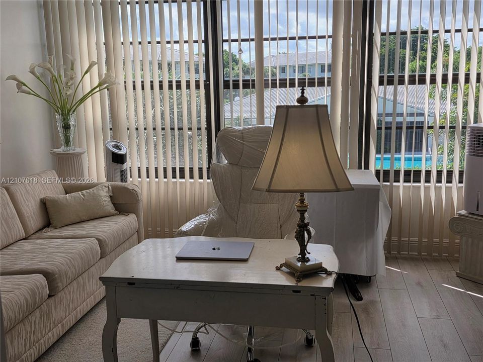 Floor-to-ceiling windows featuring vertical blinds and light-toned wood-finish flooring