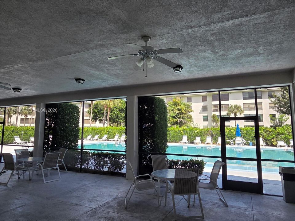 Covered outdoor patio featuring a concrete floor, built-in ceiling fans, recessed lighting, and a screened enclosure