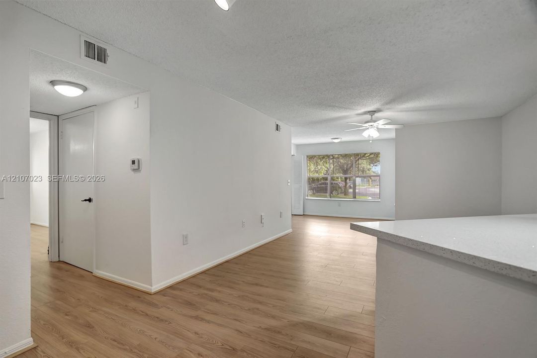 Interior featuring wood-finish flooring, recessed lighting, white built-in cabinetry with a light-colored countertop, and a ceiling fan