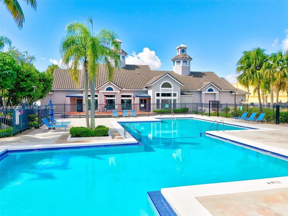 Swimming pool with blue tile border, concrete deck, and perimeter fencing