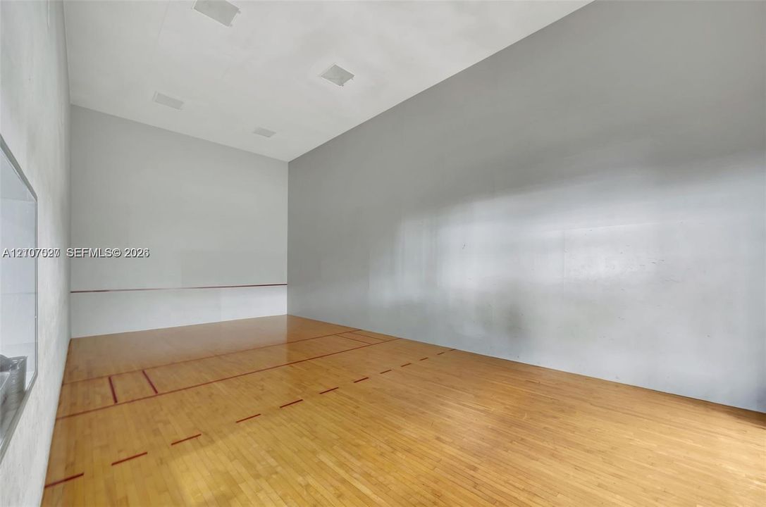 Recreational court featuring wood-finish flooring, high ceilings with recessed lighting, and smooth-finish wall surfaces