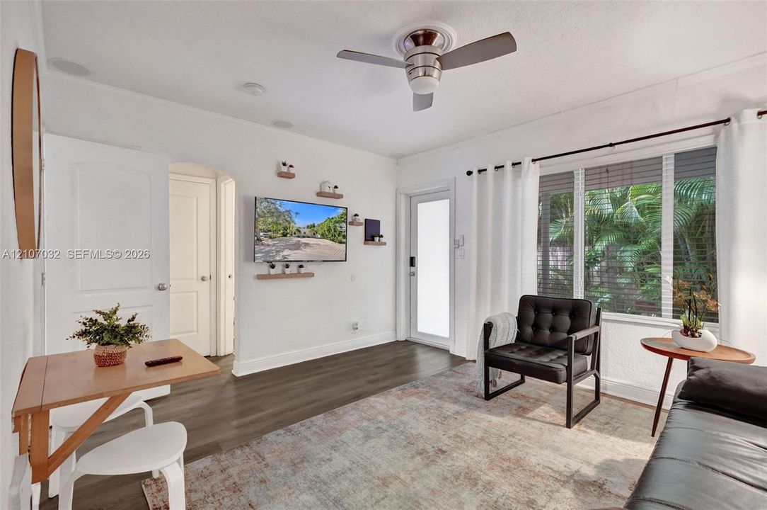 Wood-finish flooring, ceiling fan with integrated lighting, multi-panel windows, and recessed ceiling lighting