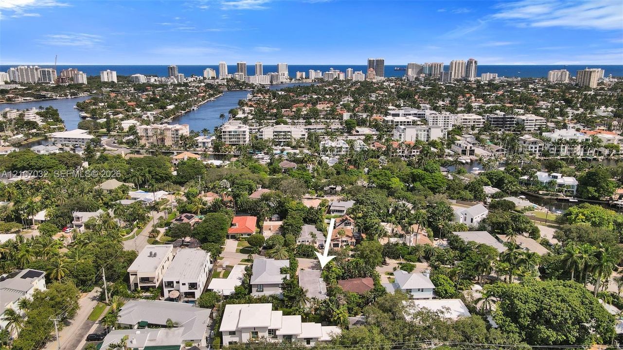 Aerial perspective featuring a residential lot with mature landscaping and proximity to regional waterways and urban coastal infrastructure