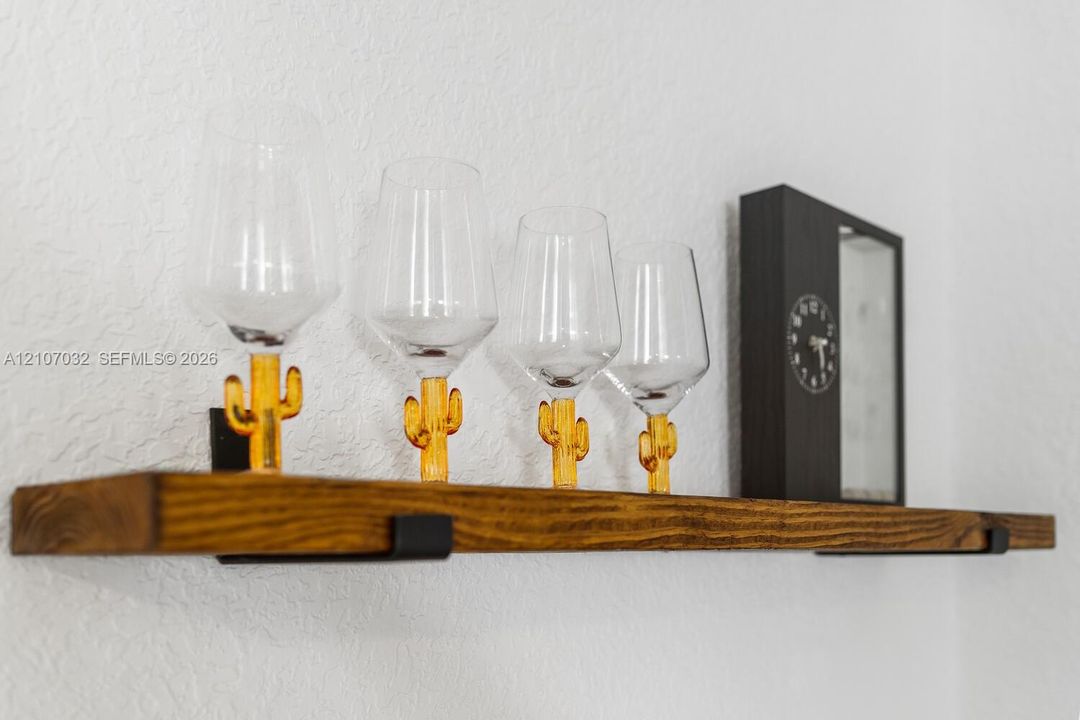 Wall-mounted floating wood shelf featuring a stained finish and matte black metal support brackets