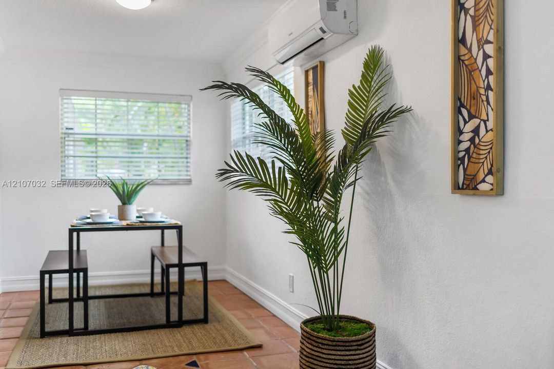 Interior space featuring ceramic tile flooring, dual-pane windows with horizontal blinds, and a wall-mounted ductless heating and cooling unit