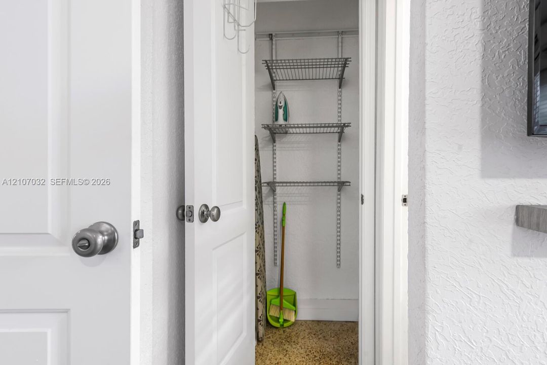 Storage closet featuring white paneled interior doors, round polished hardware, and adjustable wire shelving systems