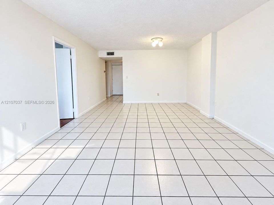 Neutral-toned interior space featuring light-colored square floor tile and a flush-mount ceiling fixture