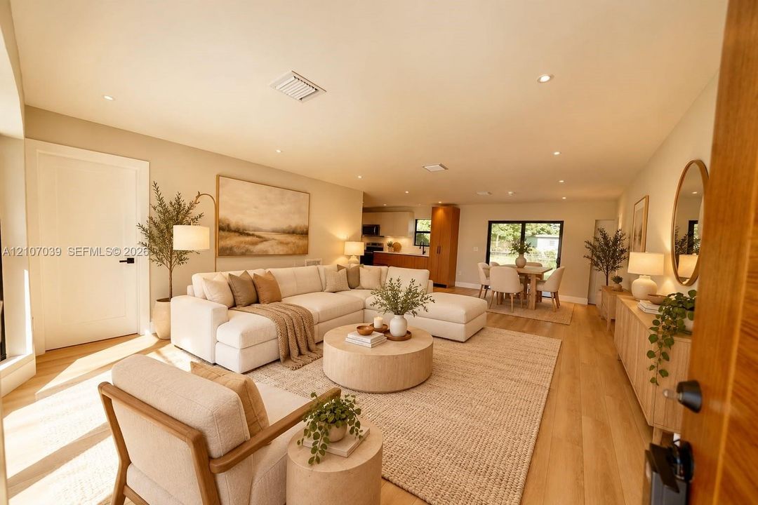Open-concept interior featuring light-toned wood-finish flooring, recessed lighting, and expansive glass sliding doors