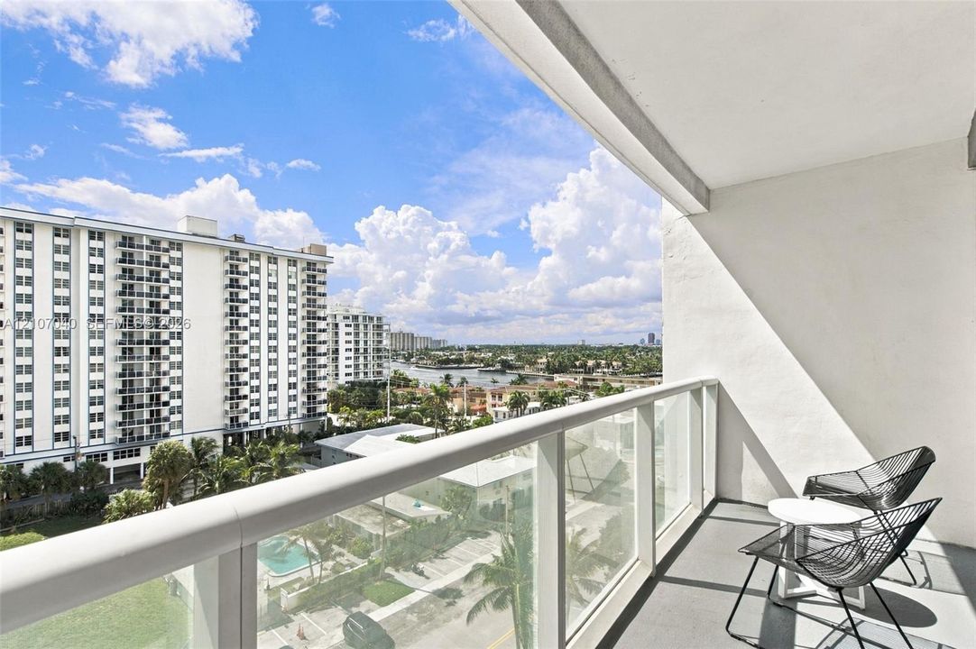 Private balcony featuring a glass-panel railing and concrete flooring