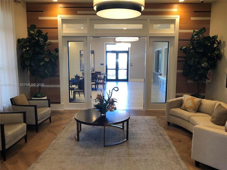 Entry area featuring wood-finish wall paneling with horizontal accent inlays, wood-finish flooring, glass-paned double doors with transom windows, and recessed drum lighting
