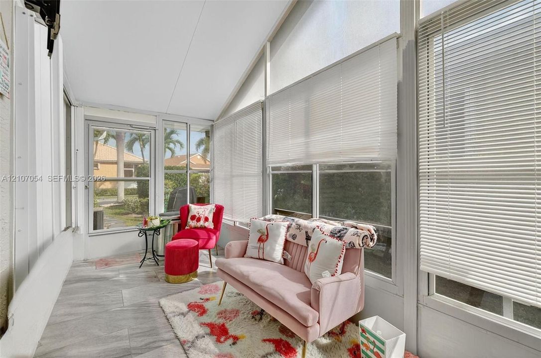 Enclosed Florida Room featuring extensive window pane walls, horizontal slatted blinds, and tile flooring