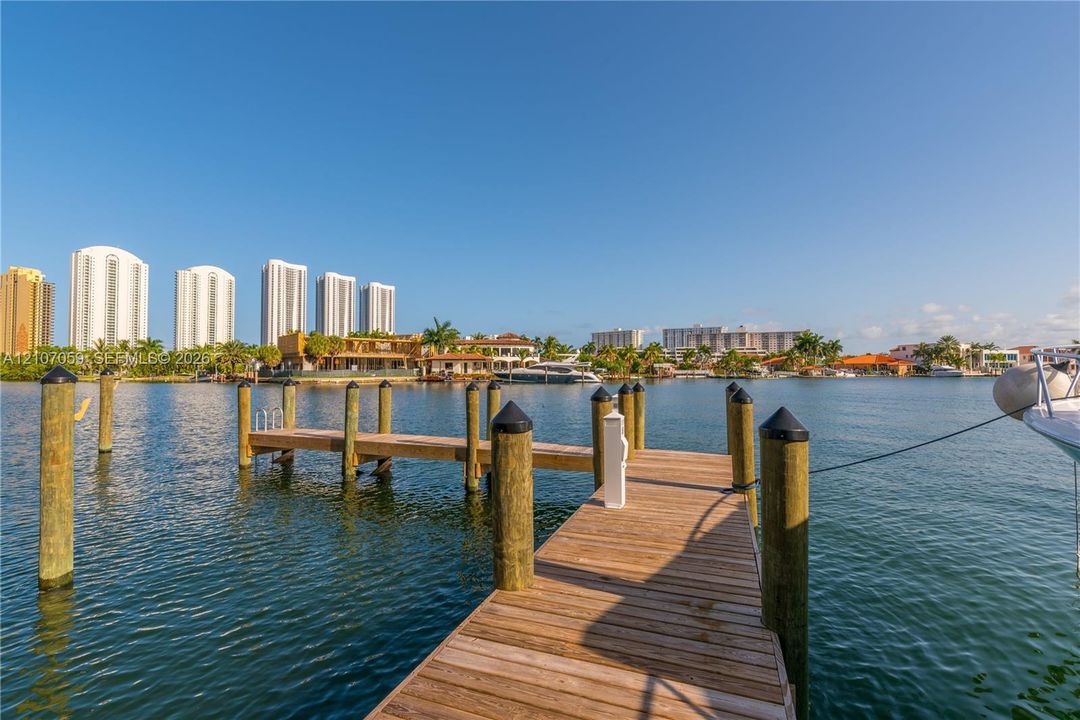 Waterfront wood-plank dock with integrated mooring pilings