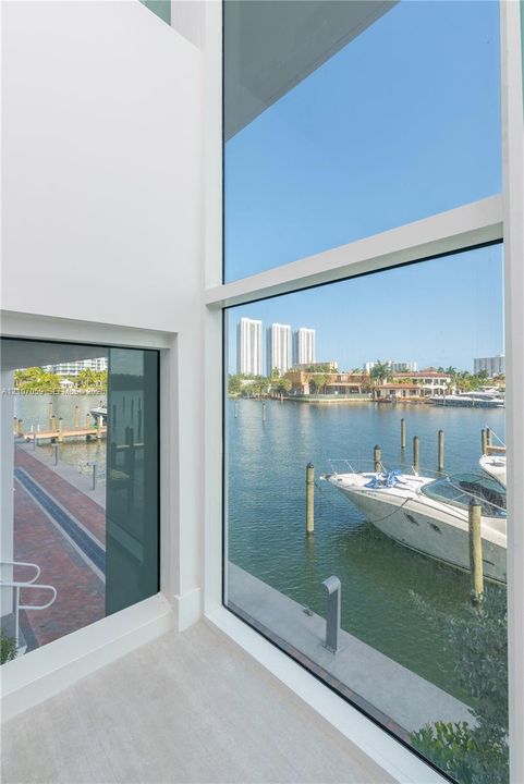 Floor-to-ceiling windows, waterfront position, concrete dock, and red brick walkway