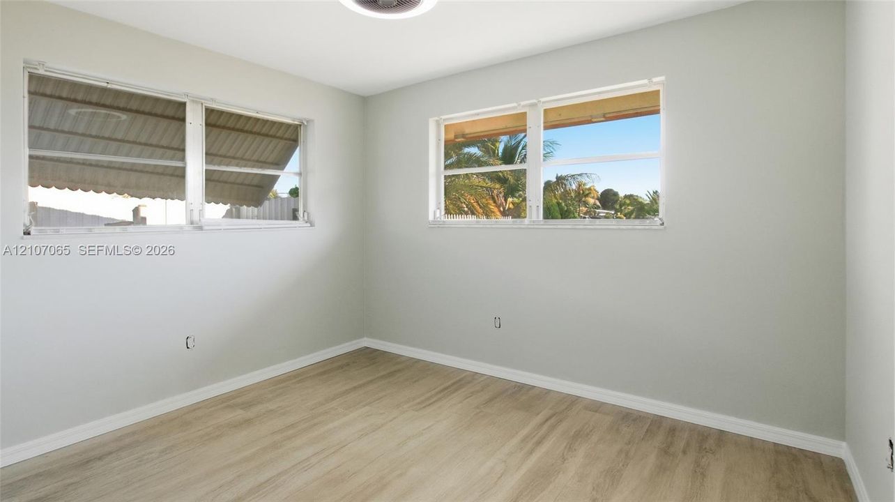 Neutral wall finishes, wood-finish flooring, and multiple dual-pane windows providing natural light