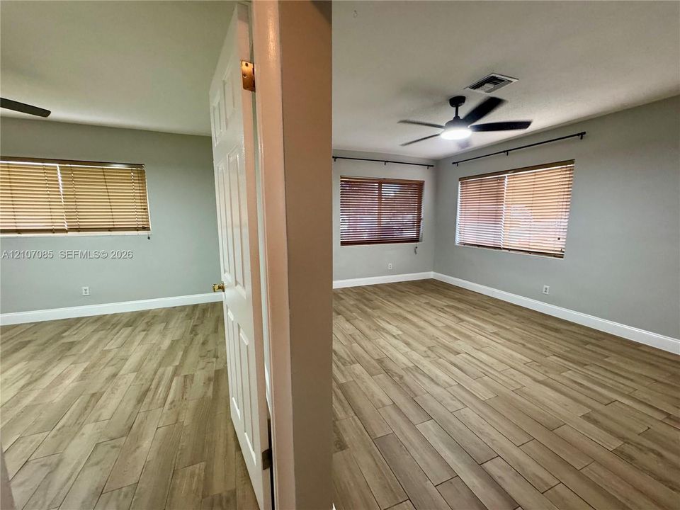 Interior spaces featuring wood-finish flooring, neutral wall paint, multi-paneled doors, and ceiling fans with integrated lighting