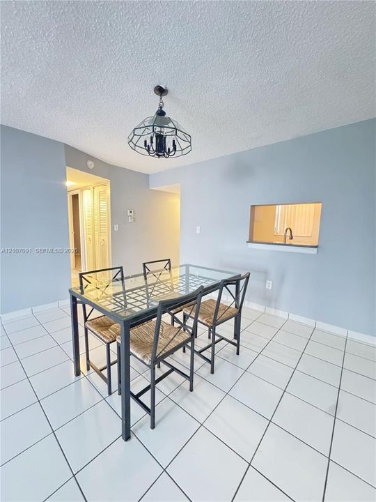 Ceramic tile flooring, geometric metal-framed overhead lighting, and an interior pass-through window with a ledge
