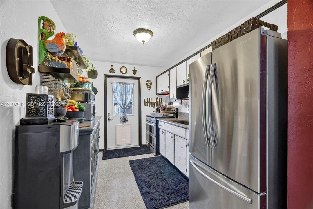 Kitchen featuring white cabinetry, stainless steel French-door refrigerator, integrated range, and flush-mount ceiling lighting