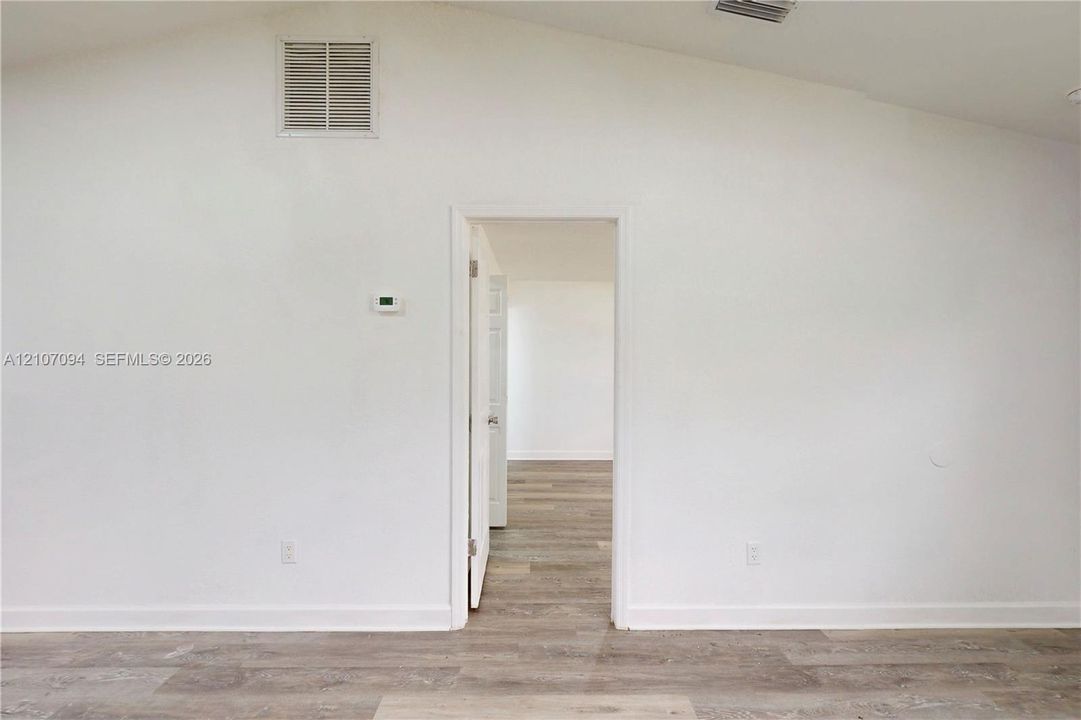 Vaulted ceiling featuring wood-finish flooring throughout
