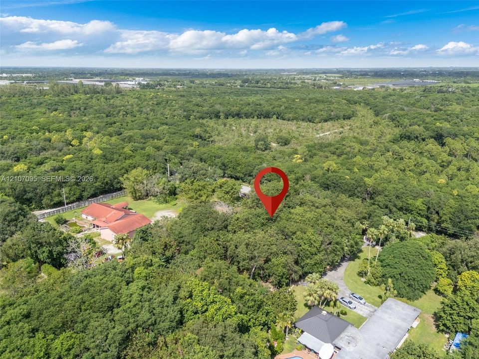 Aerial perspective of expansive wooded acreage featuring mature canopy trees and established landscape