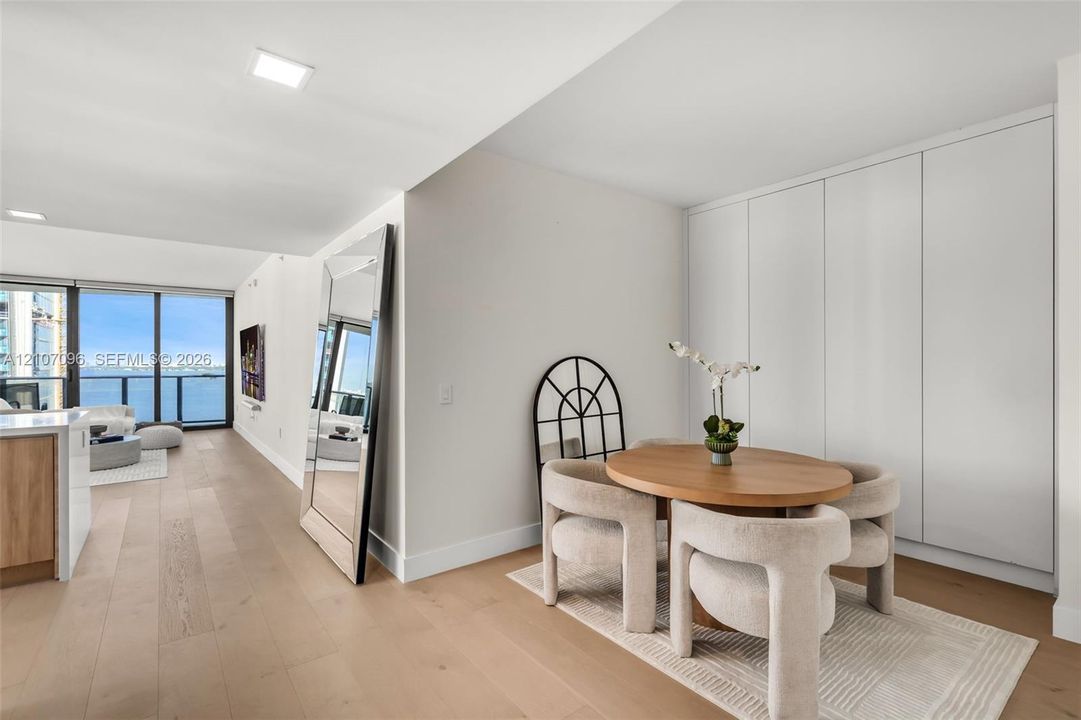 Floor-to-ceiling windows, wood-finish flooring, full-height built-in cabinetry, and recessed lighting