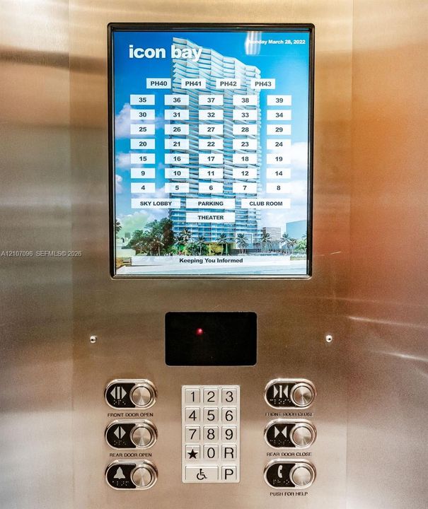 Brushed stainless steel elevator control panel featuring an integrated digital touchscreen interface, illuminated push-button keypad, and dedicated emergency communication controls
