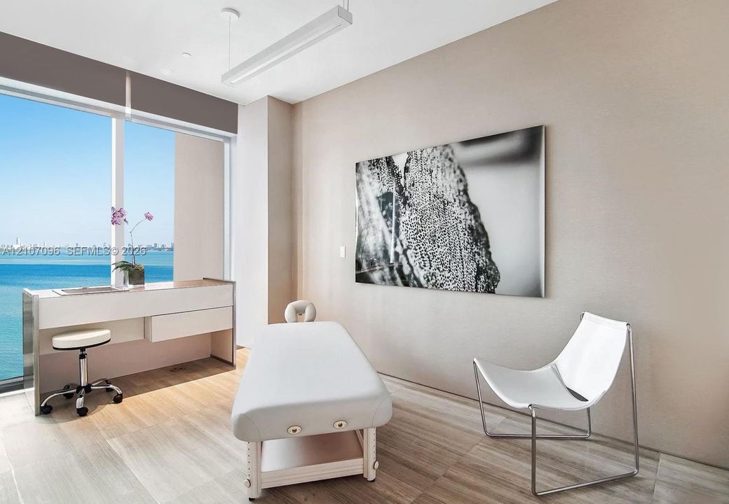 Floor-to-ceiling windows featuring expansive water scenery, wood-finish flooring, and minimalist linear overhead lighting