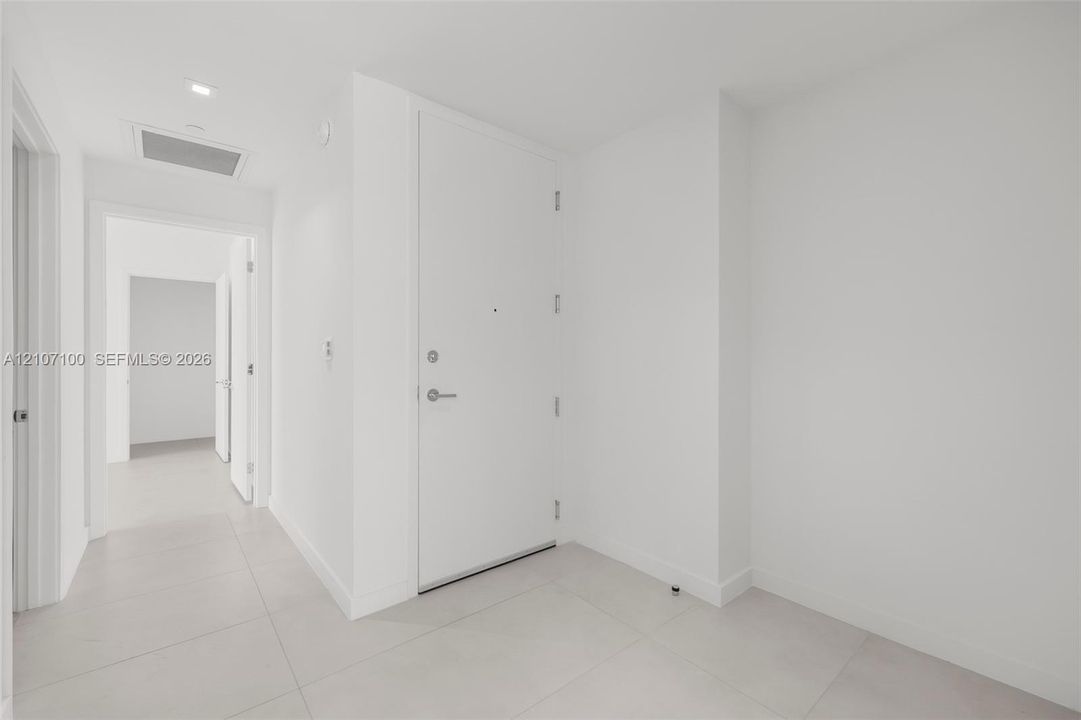 Entryway featuring large-format ceramic floor tiling, smooth-finish walls, and a recessed ceiling light fixture