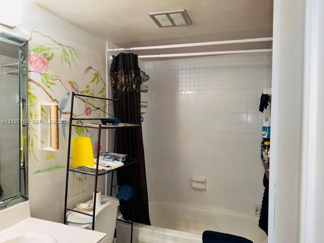 Bathroom featuring a white ceramic tile bathtub surround, built-in soap dish, and a framed mirror