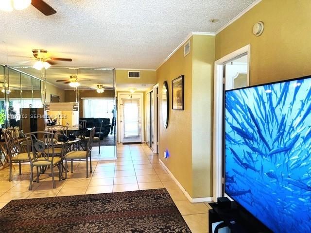 Ceramic tile flooring, full-wall mirrored accent, and ceiling-mounted light fixtures