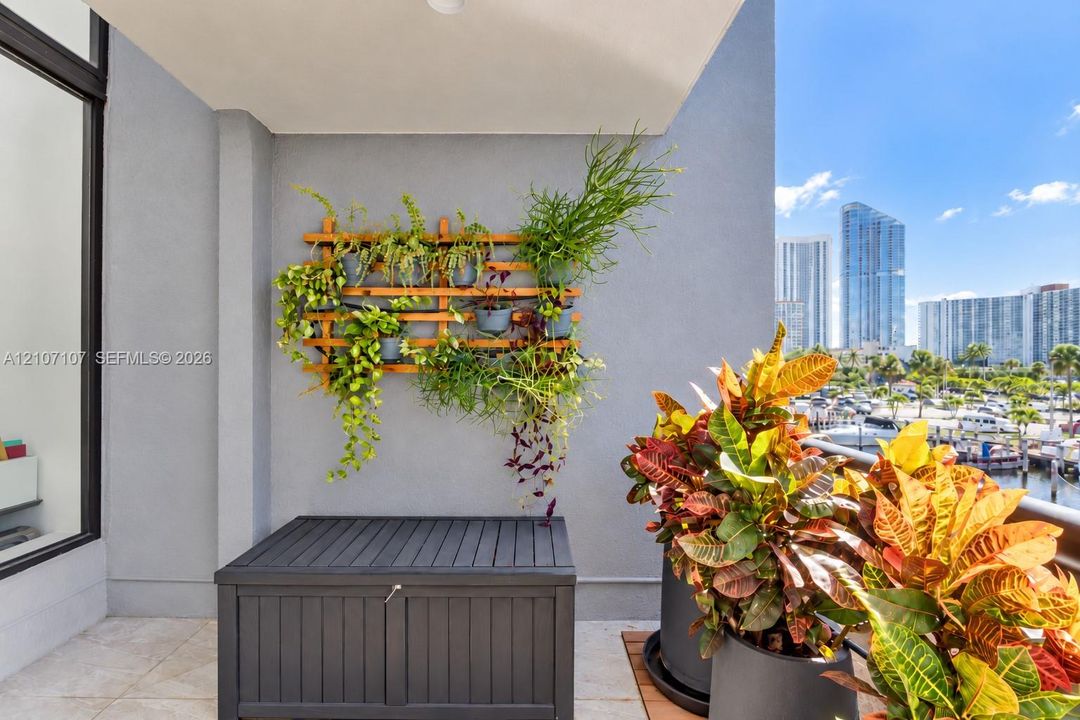 Private balcony featuring large-format tile flooring and a wall-mounted wooden trellis