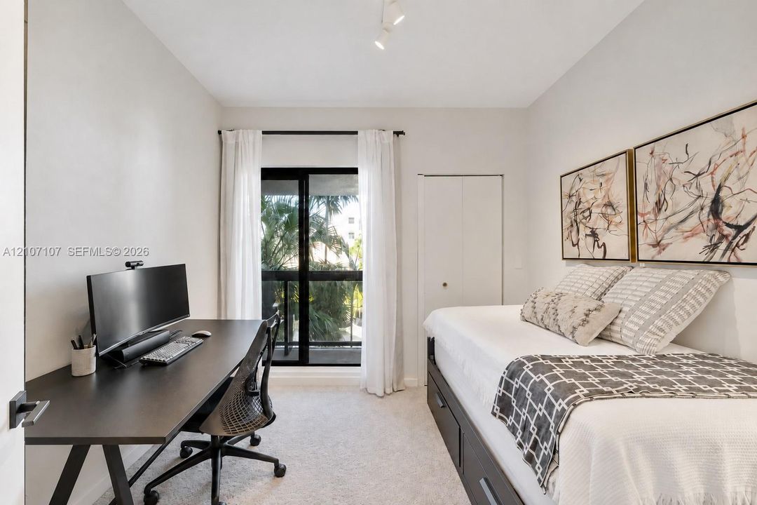 Neutral-toned room featuring wall-to-wall carpeting, sliding glass doors providing outdoor access, and a closet with dual-panel doors