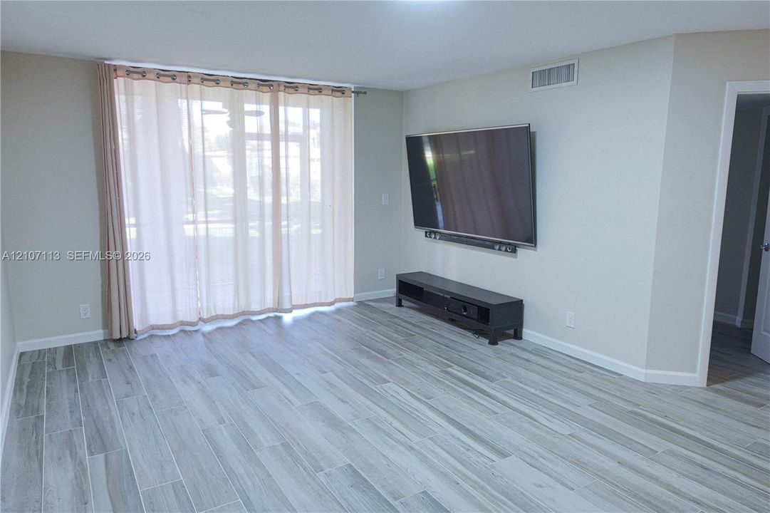 Wood-finish flooring, large sliding glass door, and neutral wall color