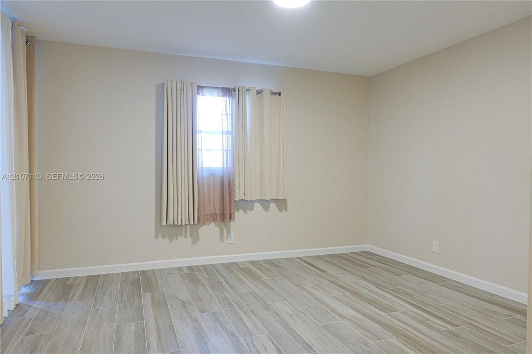 Neutral interior featuring wood-finish flooring, light-toned wall paint, and recessed ceiling lighting