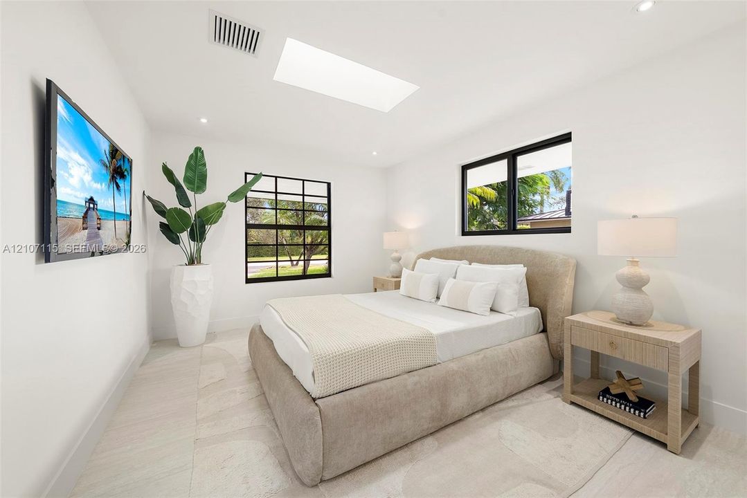 Skylight, large-format tile flooring, and multi-pane windows with black frames