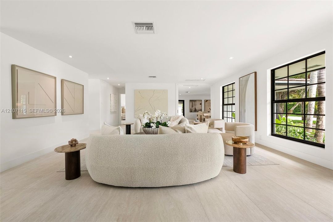 Interior space featuring light-toned flooring, expansive windows with black frames, and recessed lighting