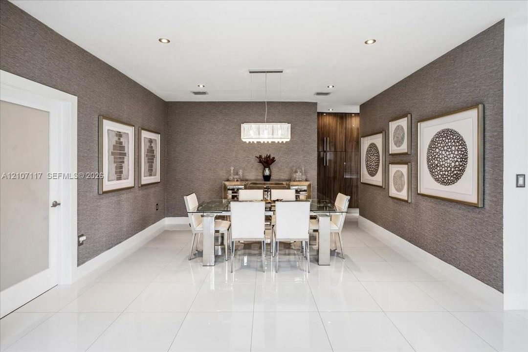 Large-format tile flooring, textured wall coverings, rectangular multi-tier chandelier, and recessed lighting