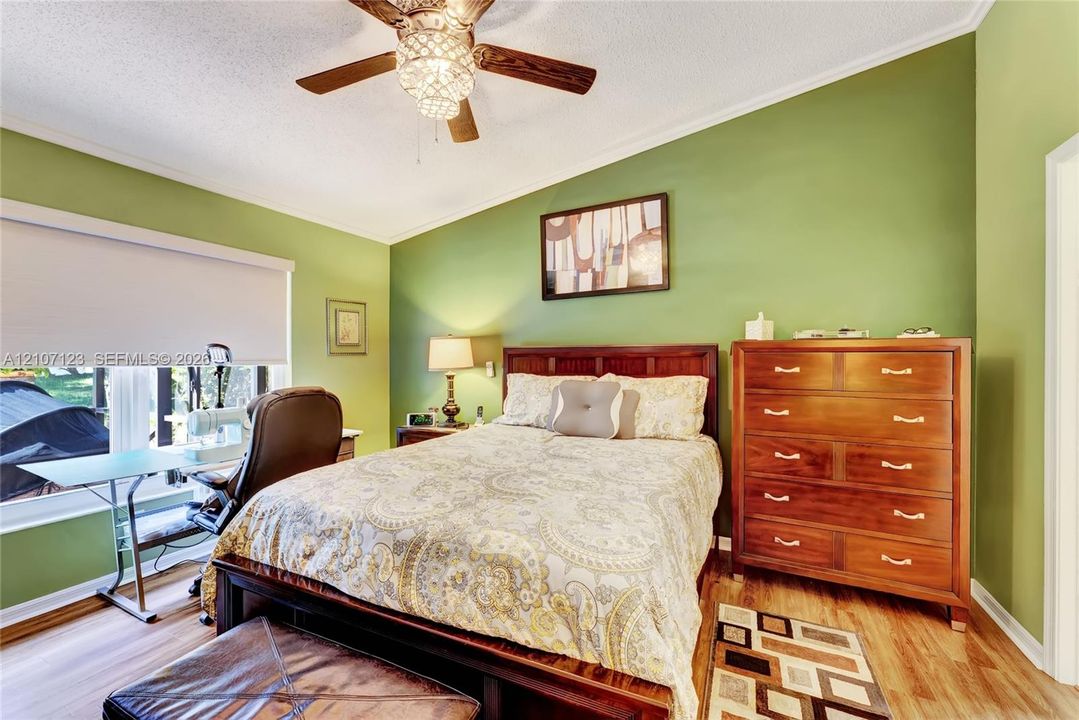 Vaulted ceilings, wood-finish flooring, and a ceiling fan with integrated lighting