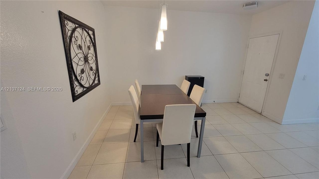 Ceramic tile flooring, neutral wall finishes, and a contemporary trio of pendant light fixtures