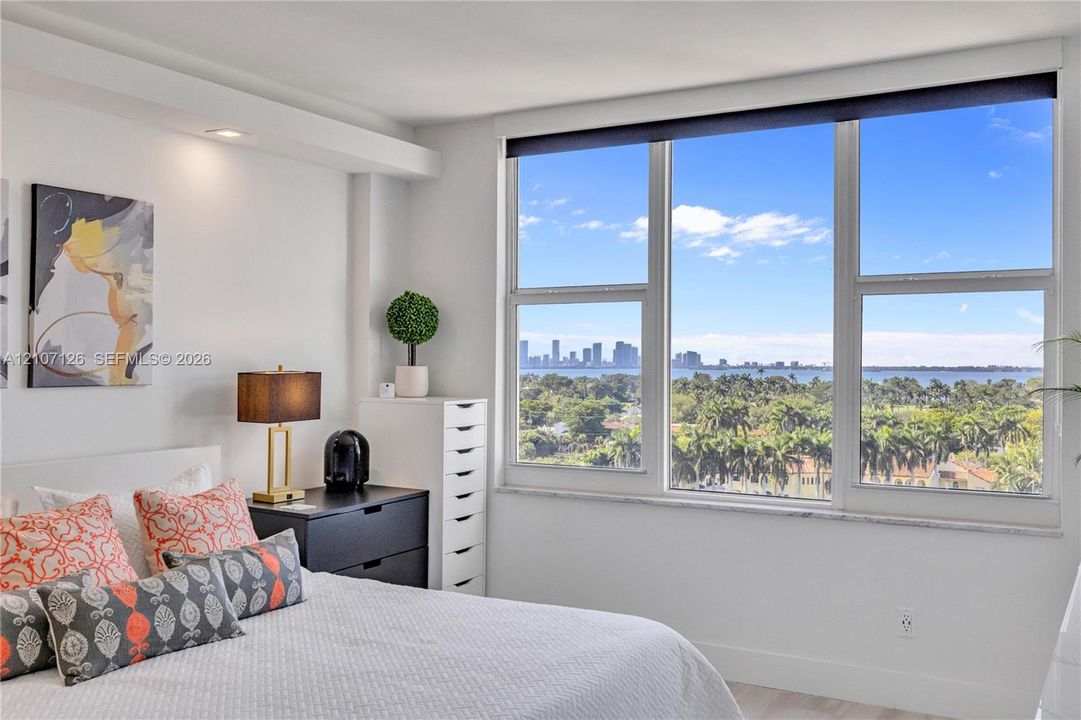 Floor-to-ceiling windows featuring panoramic water and city skyline outlooks, recessed ceiling lighting, and smooth-finish walls