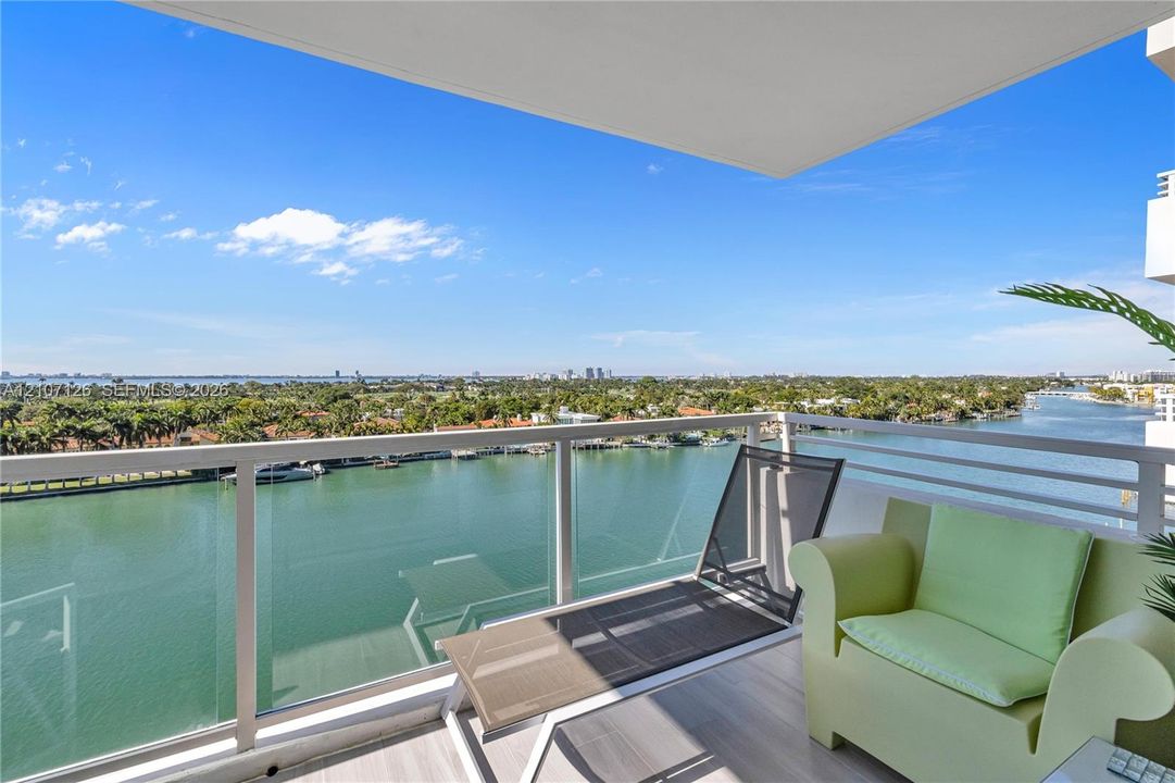 Covered private balcony featuring glass panel railings and wood-finish flooring