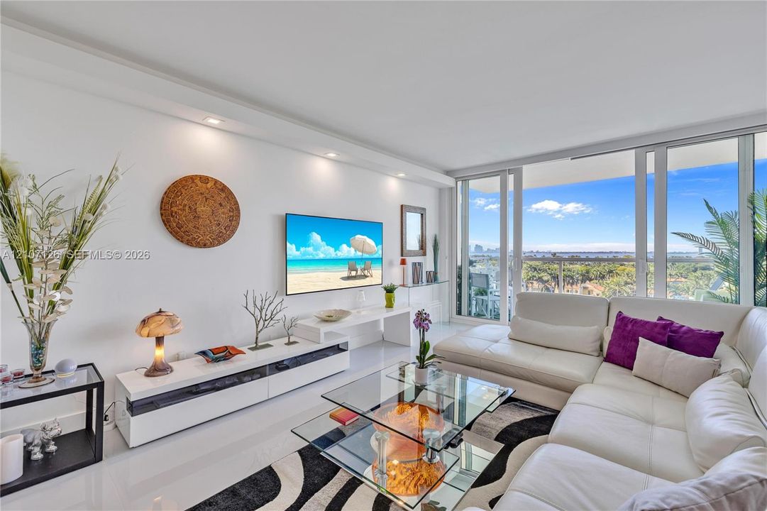 Living area featuring floor-to-ceiling glass sliding doors, polished tile flooring, and recessed ceiling lighting