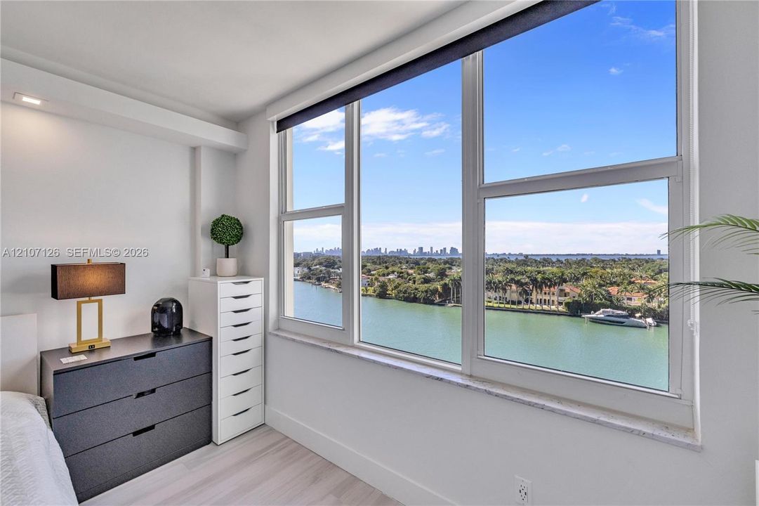 Floor-to-ceiling windows with stone sill, wood-finish flooring, and recessed ceiling lighting