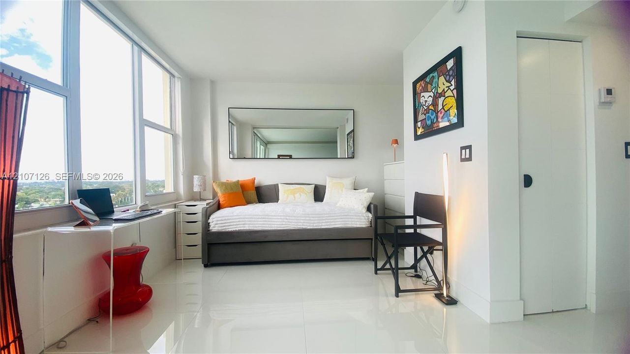 Floor-to-ceiling windows, polished white flooring, and wall-mounted mirror