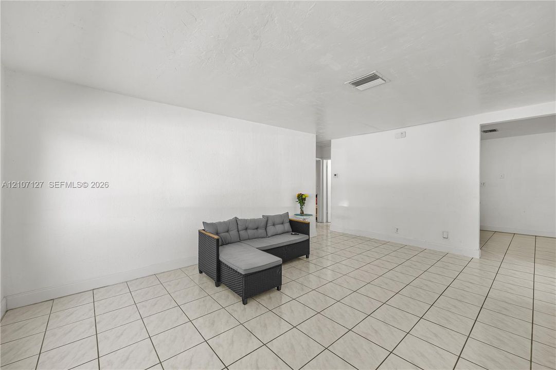 Neutral-toned interior featuring smooth white walls and ceramic tile flooring