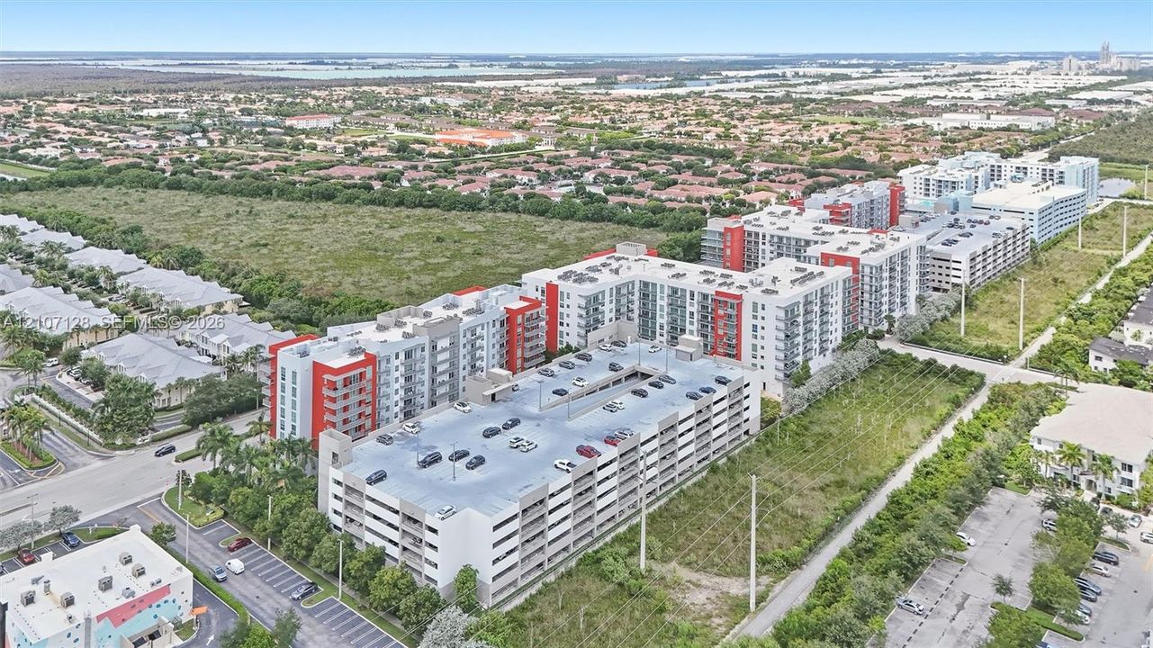 Multi-story residential complex featuring a structured parking garage and balcony units