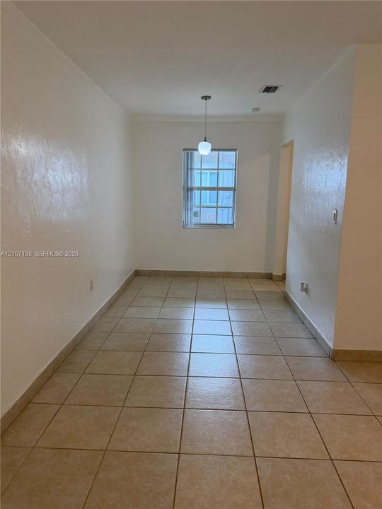 Square ceramic tile flooring, neutral wall finishes, and a single-light pendant fixture