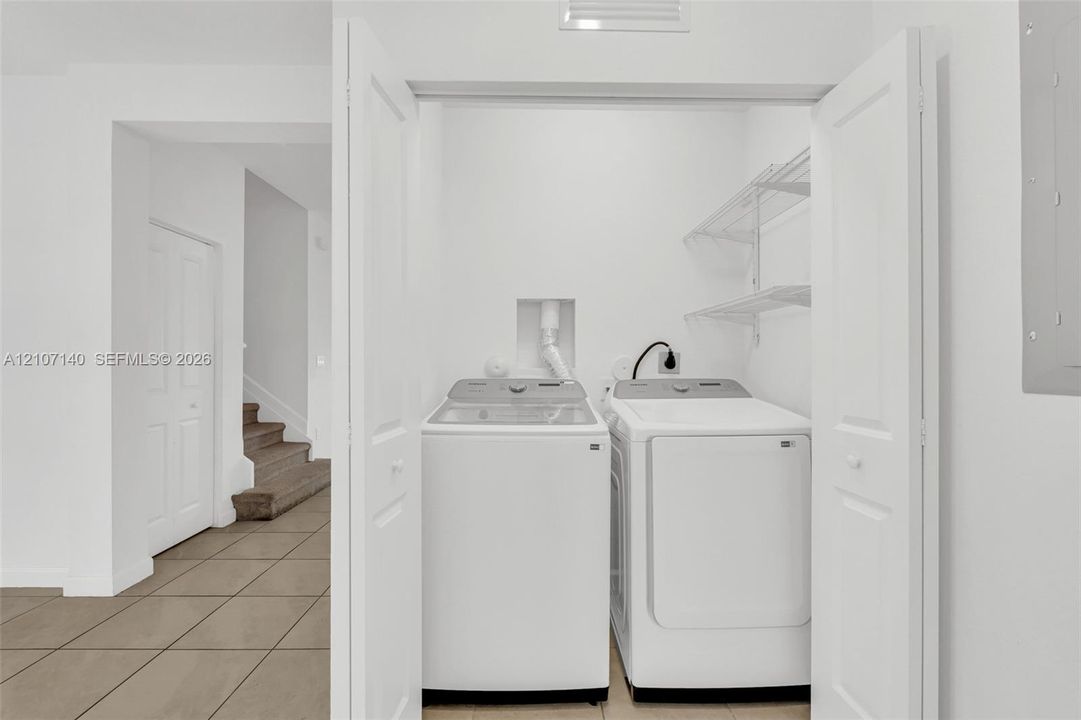 Laundry closet featuring bi-fold doors, white interior walls, and wall-mounted wire shelving